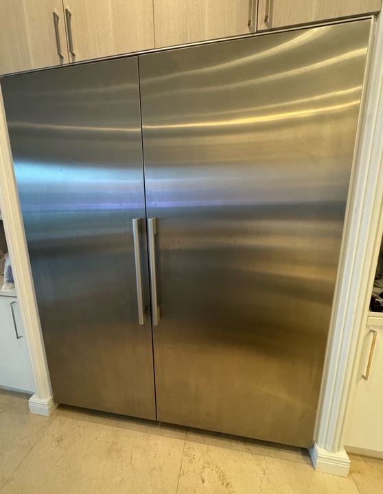 Pair of stainless built-in column refrigerator and freezer units set into cabinetry