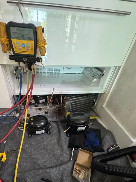 Fieldpiece digital manifold hooked to a built-in refrigerator with two compressors on the floor mat