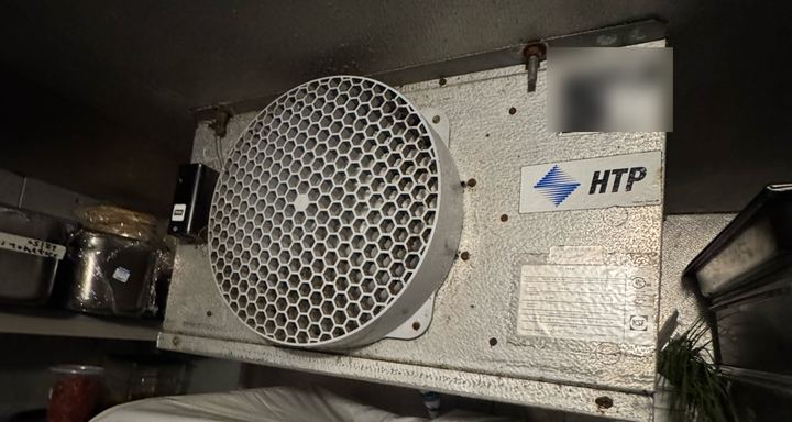 HTP unit cooler with a round fan guard mounted to the ceiling inside a walk-in cooler