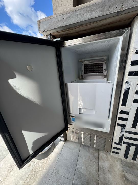 Maxx Ice undercounter ice maker installed outdoors with the door open showing the evaporator and ice bin