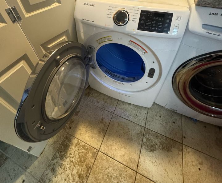 Samsung front-load dryer with the door open in a laundry room