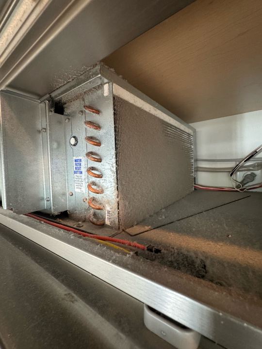Sub-Zero condenser coil and copper tubing covered with dust in the machine compartment