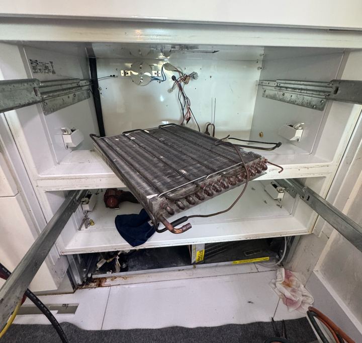 Sub-Zero built-in refrigerator with the evaporator coil pulled forward out of its compartment